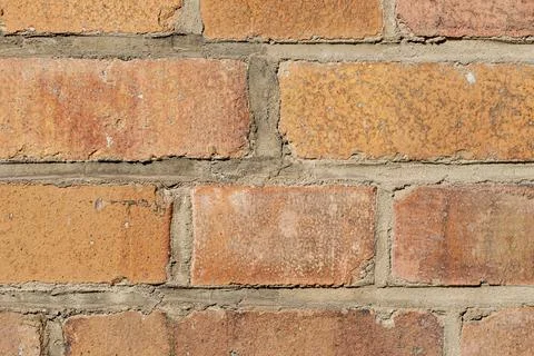 Close-up of rustic brick wall with cracks and mortar lines Stock-Fotos