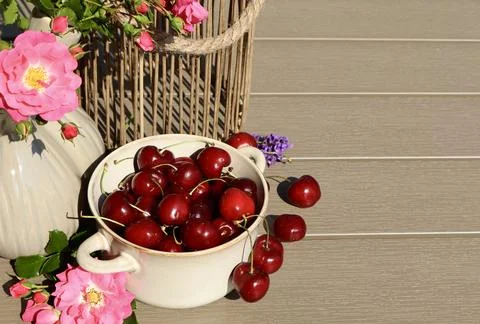 A close-up of a rustic ceramic bowl filled with ripe red cherries Stock Photos