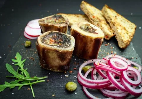 Close up of rustic english bone marrow, pickled onion and toast Stock Photos