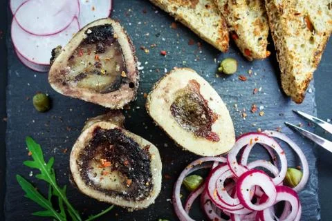 Close up of rustic english bone marrow, pickled onion and toast Stock Photos