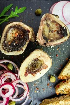 Close up of rustic english bone marrow, pickled onion and toast Stock Photos