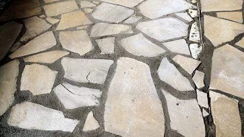 Close up of rustic flagstone floor with irregular shaped beige stones set i.. Stock Photos