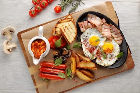 Close up of rustic full english breakfast on a white wooden table Stock Photos