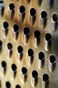 Close-up of a rustic kitchen tool with rhythmic perforated holes. Macro of .. Stock Photos