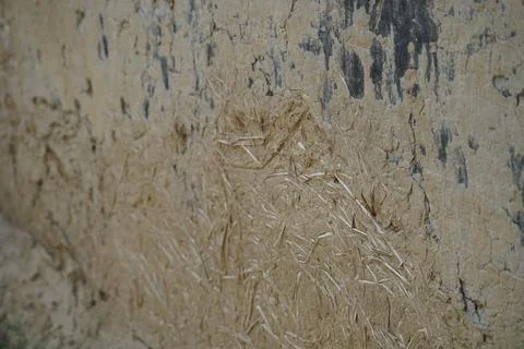 Close up of a rustic mud and straw wall texture in a rural agricultural setting. Stock Photos