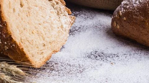 Close up of rustic sourdough bread with scattered flour and wheat stalks Stock Photos