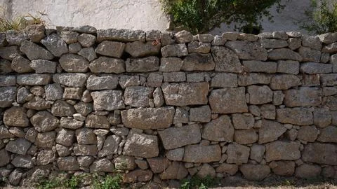 Close-up of rustic stone wall with irregular granite rocks Stock Photos