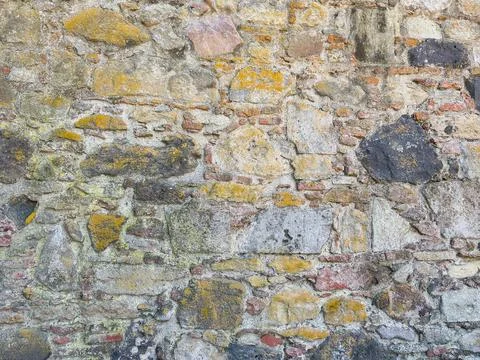 Close-up of rustic stone wall with irregular granite rocks Stock Photos