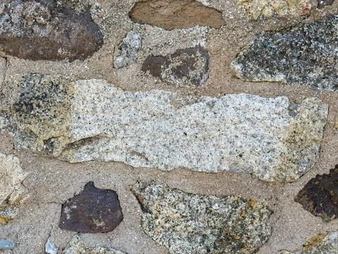 Close-up of rustic stone wall with irregular granite rocks Stock Photos
