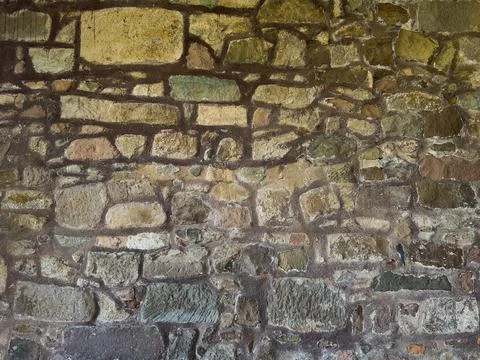 Close-up of rustic stone wall with irregular granite rocks Stock Photos
