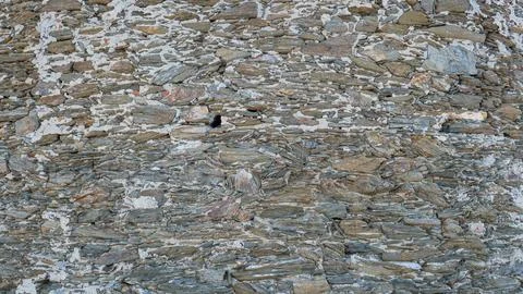 Close-up of rustic stone wall with irregular granite rocks Stock Photos