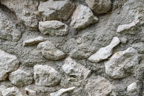 Close-up of rustic stone wall with uneven texture and natural color variations Stock Photos