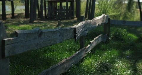 Close-up of a rustic timber fence with sunlit grass, audio included Stock-Footage 334670348