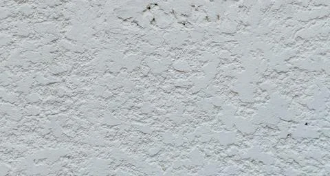 Close-up of a rustic white concrete wall with a highly textured. Stock Photos