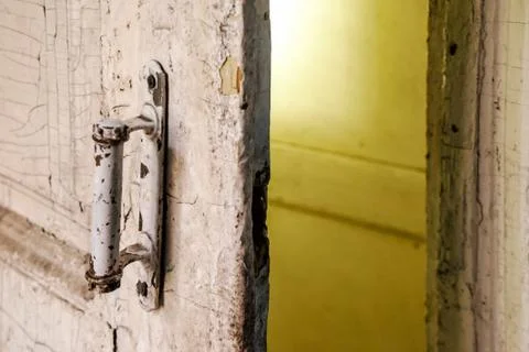 Close-up of the rustic white door handle in the room of abandoned shabby buil Stock Photos