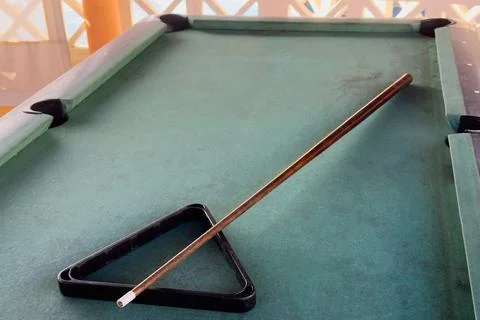 Close up of a rustic wooden triangle pool rack and worn billiard cue stick .. Stock Photos