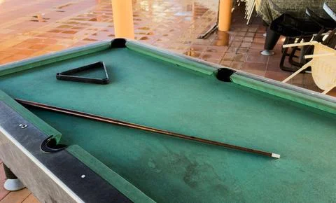 Close up of a rustic wooden triangle pool rack and worn billiard cue stick .. Stock Photos