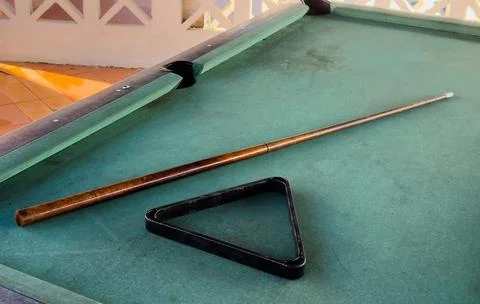Close up of a rustic wooden triangle pool rack and worn billiard cue stick .. Stock Photos
