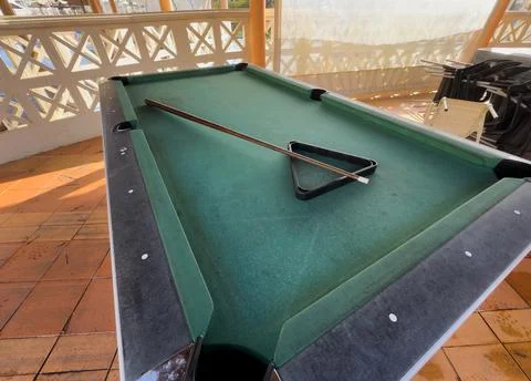 Close up of a rustic wooden triangle pool rack and worn billiard cue stick .. Stock Photos
