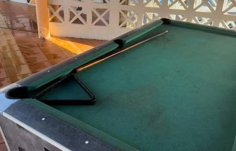 Close up of a rustic wooden triangle pool rack and worn billiard cue stick .. Stock Photos