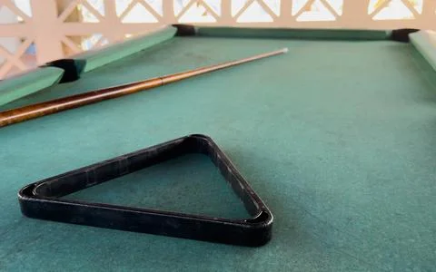 Close up of a rustic wooden triangle pool rack and worn billiard cue stick .. Stock Photos