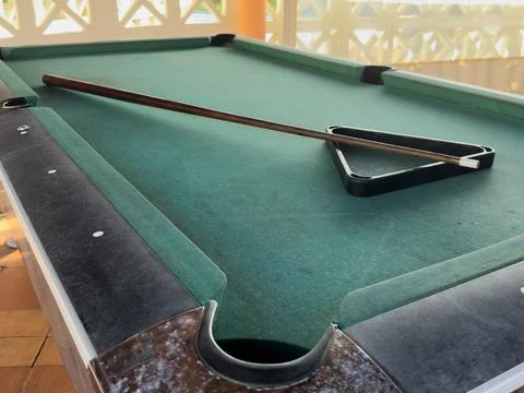 Close up of a rustic wooden triangle pool rack and worn billiard cue stick .. Stock Photos