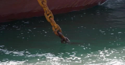 A close-up of a rusty anchor chain lowered into the sea. Stock Footage 165626499