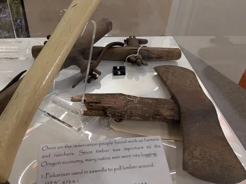 Close-up of a rusty antique axe and historic wooden tool displayed Stock-Fotos