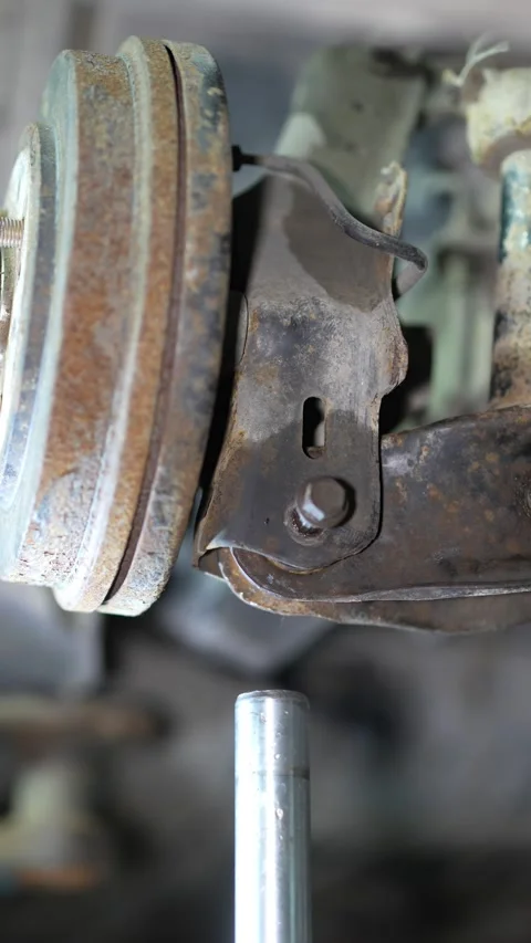 Close-up of a rusty brake drum and car suspension arm. Stock Footage 345708149
