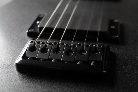 A close-up rusty bridge serves to secure the strings to an electric guitar. B Foto stock