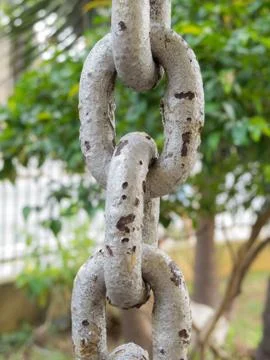 Close up of rusty chain links in the foreground Stock Photos