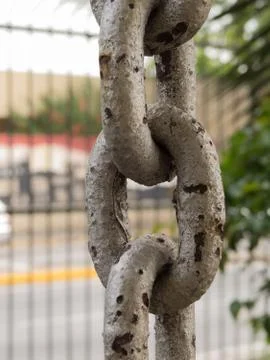 Close up of rusty chain links in the foreground Stock Photos