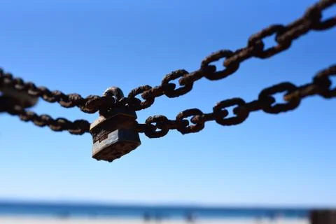 Close up of a rusty chain secured by a pad lock Stock Photos