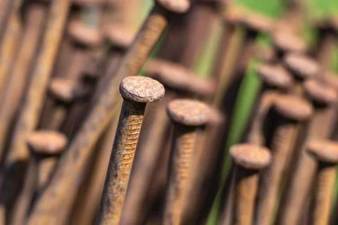 Close-up of rusty iron nails stacked together showing weathered metal texture Stock Photos