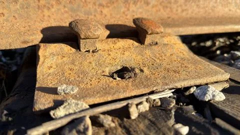 Close-up of rusty railroad track components on gravel Foto stock