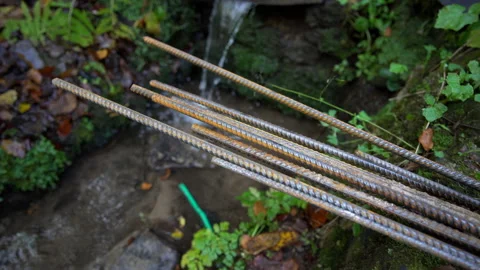 Close up of rusty reinforcement rod, falling water in the background Stock Footage 158976598