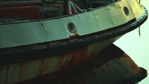 Close-up of a rusty ship hull docked at the pier with yellow and cyan sunri.. Stock Footage 328460513