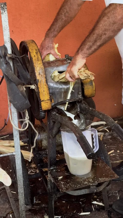 Close-Up of a Rusty Sugarcane Press and Vendor’s Arm Operating it in a Bustling Stock Footage 300602056