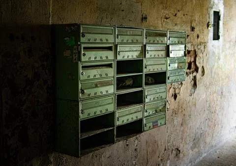 Close-up of rusty vintage mailboxes inside an abandoned house. Stock Photos