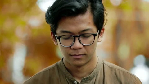 Close-up of sad and thoughtful handsome asian man looking at camera Stock Footage 86140637
