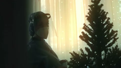 Close-up of the sad doctor in protective suit and visor decorates the Christmas Stock Footage 145470204