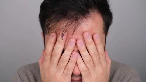 Close Up of Sad Man Covering Face with Hand Stock Footage 260724305