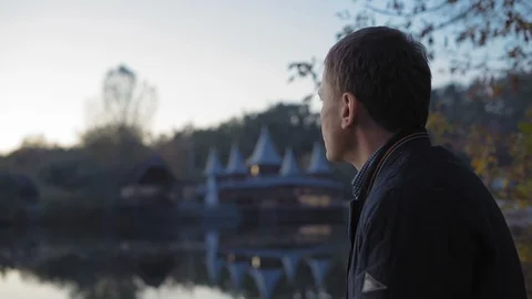 Close-up, Sad Man Drinks Tea in the Autumn Park Near the Lake Stock Footage 97721476