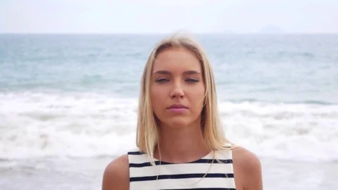 Close Up sad pensive pretty young blonde woman looking at camera over background Video stock 82605502