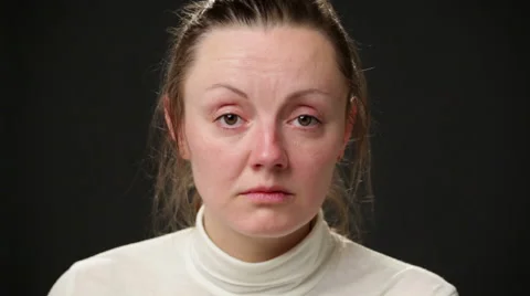 Close up sad woman's face against gray background Video stock 64057553