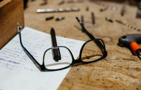 Close-up of safety glasses and notes on carpenter's workbench Stock Photos