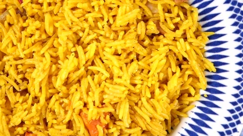 Close-Up of Saffron Yellow Rice on a Blue Patterned Plate, Warm Spiced Side Dish Stock Footage 337982538