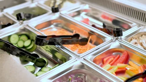 A close-up of a salad bar featuring fresh vegetables, including cucumbers Stock Footage 278017568