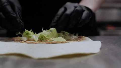 Close-Up of Salad Placement on Lavash Base with Sauce: Street Food Prep Video stock 307058368