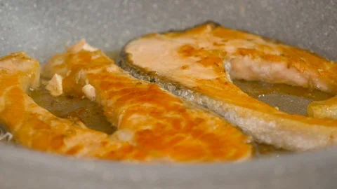 Close up on salmon steaks browning in no stick pan Video stock 127905191
